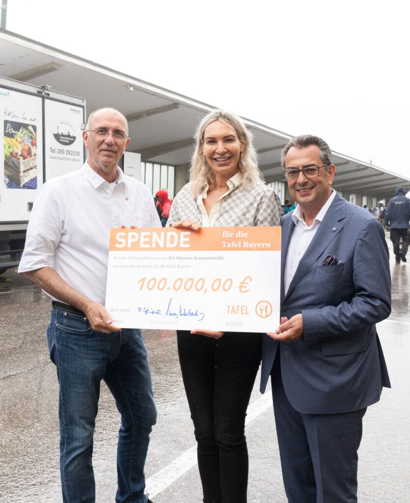 Stavros Kostantinidis (r.) und seine Frau Saskia überreichen Peter Zilles, Vorsitzender der Tafel Bayern, den Spendenscheck für die Tafel Bayern.