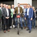 Im Rahmen der Eröffnung kam es auch zur Übergabe von acht Elektro-Lastenrädern. V.l.n.r.: Jonah Lindinger, stellvertretende Vorsitzende Tafel Deutschland e.V., Alex Brunner, stellvertretender Vorsitzender Tafel Bayern e.V., Andreas Steppuhn, Vorsitzender Tafel Deutschland e.V., Gabi Schmidt, MdL Ehrenamtsbeautragte, Thomas Huber, MdL, Ministerpräsident Dr. Markus Söder, Peter Zilles, Vorsitzender Tafel Bayern e.V., Marcus König, Oberbürgermeister Stadt Nürnberg. Foto: Jörg Weber, wbr-Studio